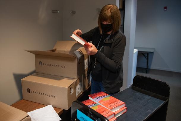 Pat unpacks boxes filled with new materials to be processed.